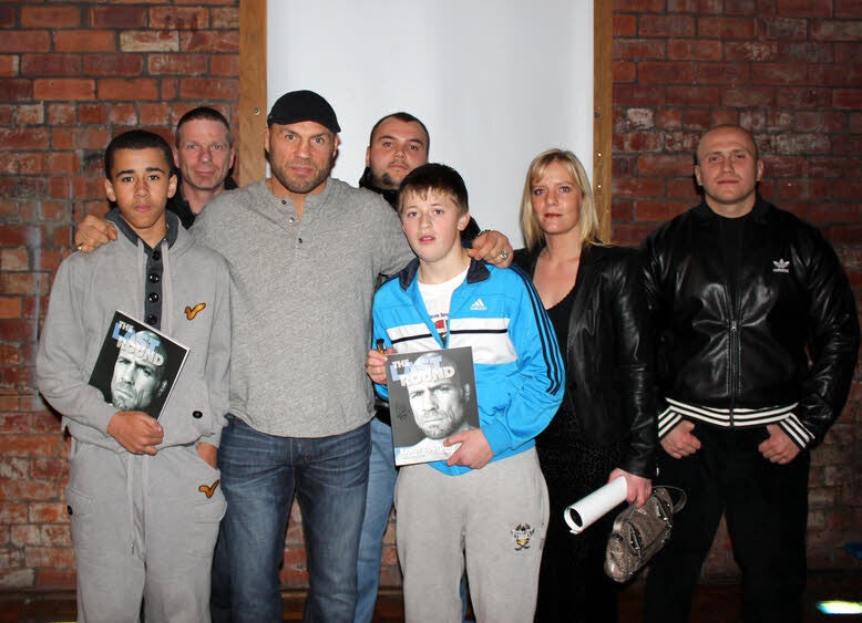 Darren Taylor and his young students meet Randy Couture in Leeds, holding The Last Round books