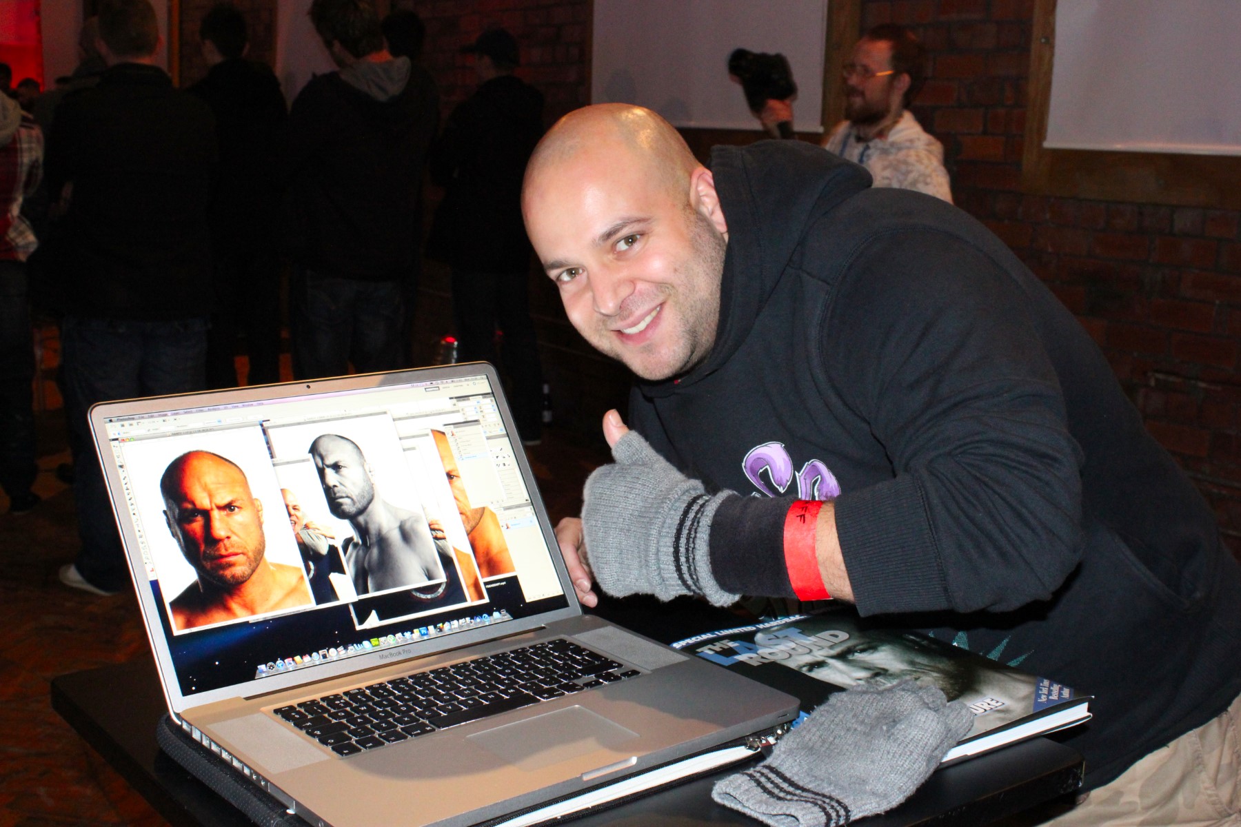 A graphic designer showing his digital portrait work of Randy Couture on a MacBook Pro in Leeds