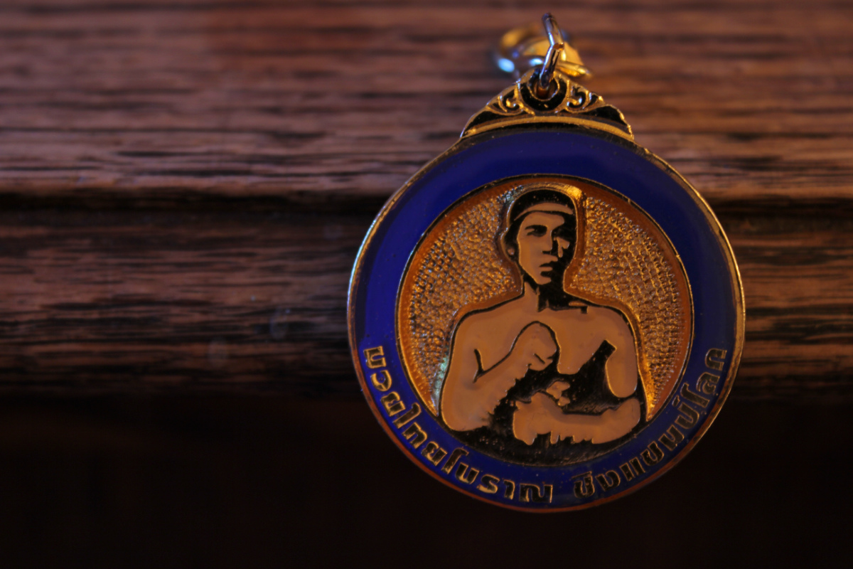 Daz's own Nai Kha Knomtom medallion - blue enamel and gold with a Muay Thai fighter