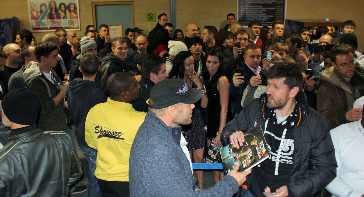 Randy Couture surrounded by fans signing books in Nottingham