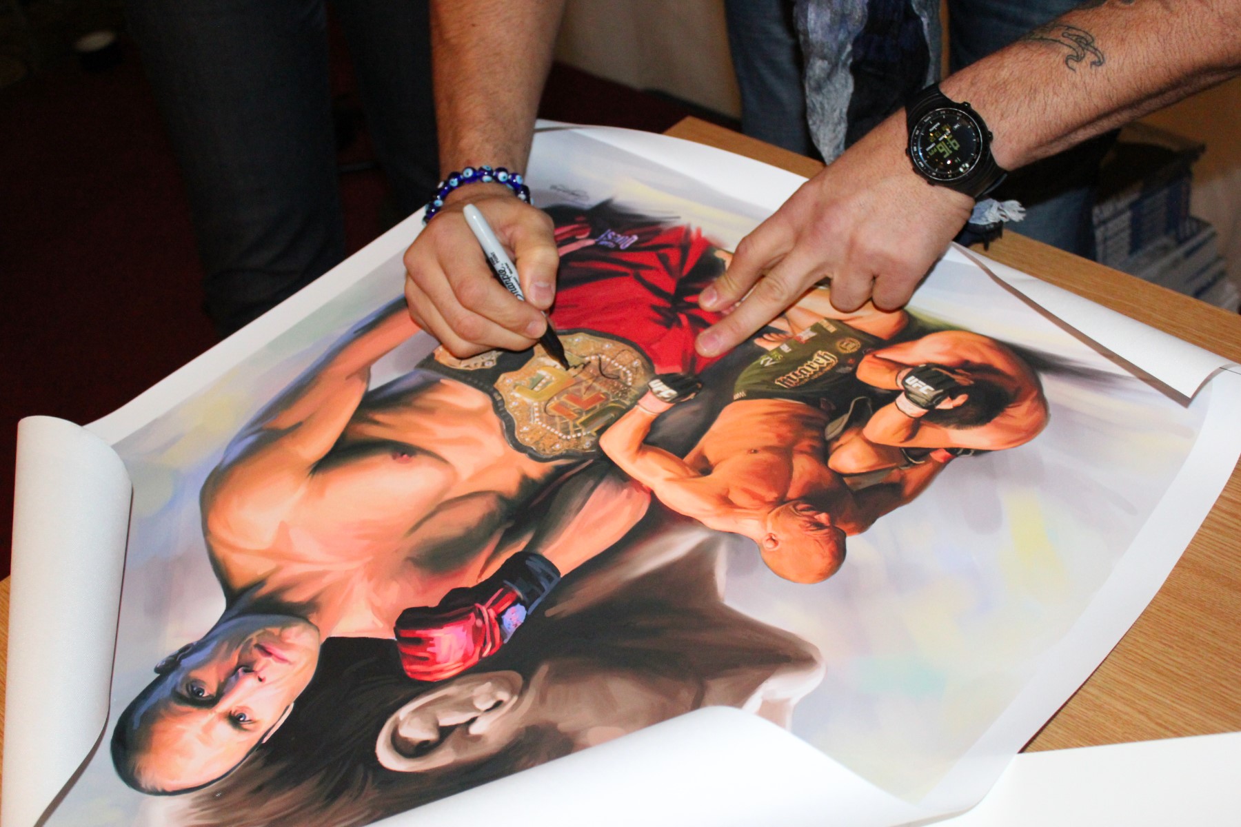 Randy Couture signing a stunning watercolour painting of himself in Scotland
