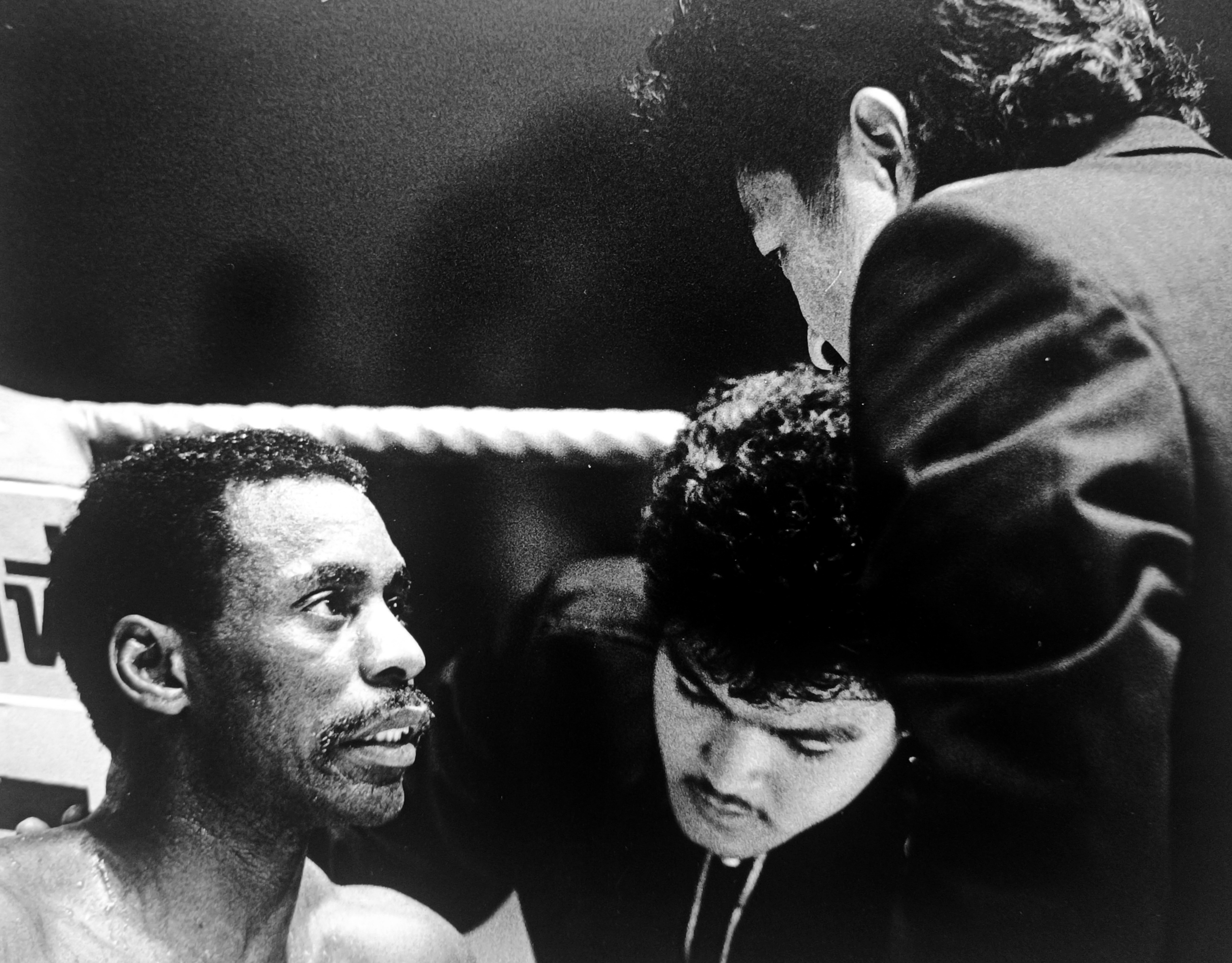 Close-up of Ronnie Green looking up at his corner man between rounds, sweat visible, intimate moment