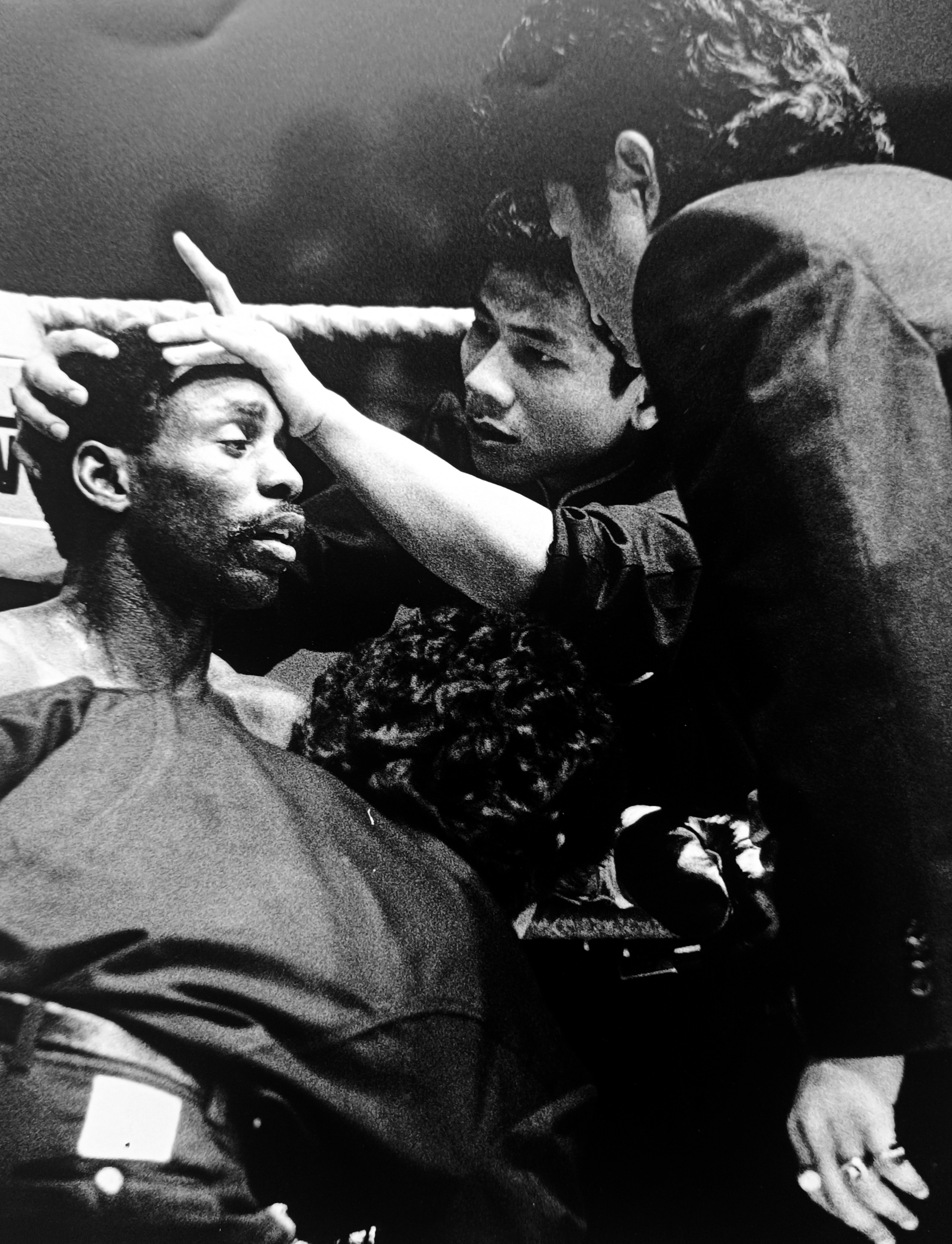 Ronnie Green's corner man pressing his forehead and examining him between rounds, intimate close-up