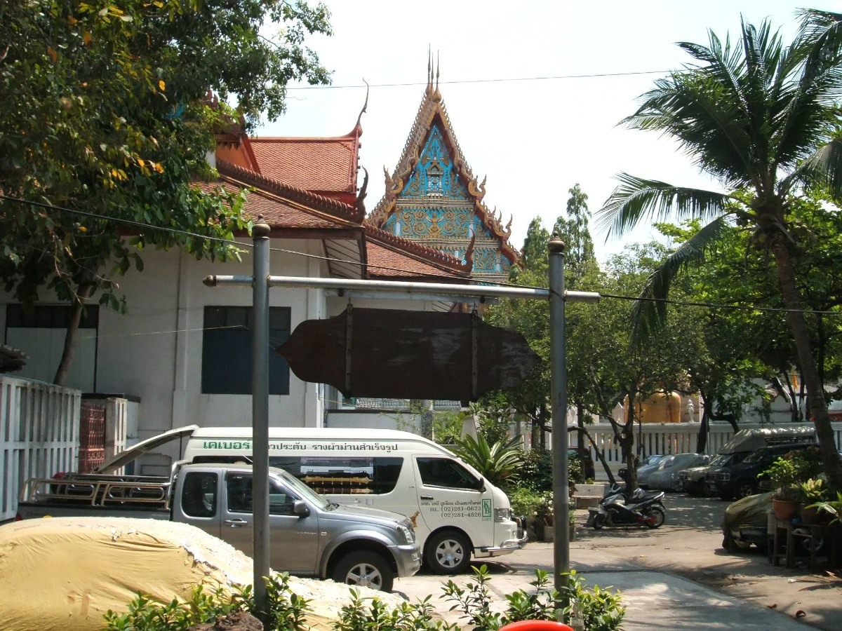 Saengmorakot Camp with Thai temple visible in the background, palm trees and Bangkok street life
